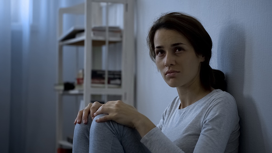 נערה יושבת על רצפת בית חולים פסיכיאטרי