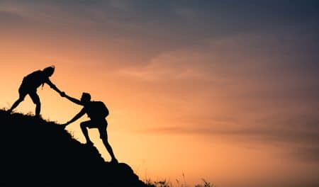 איש עוזר לחבר לטפס הר