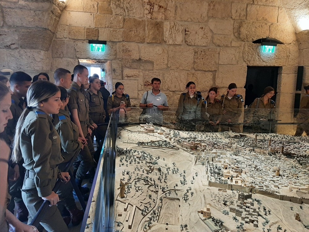 קבוצת חיילים וחיילות מביטים על דגם מוקטן של ירושלים במגדל דוד מוזיאון ירושלים
