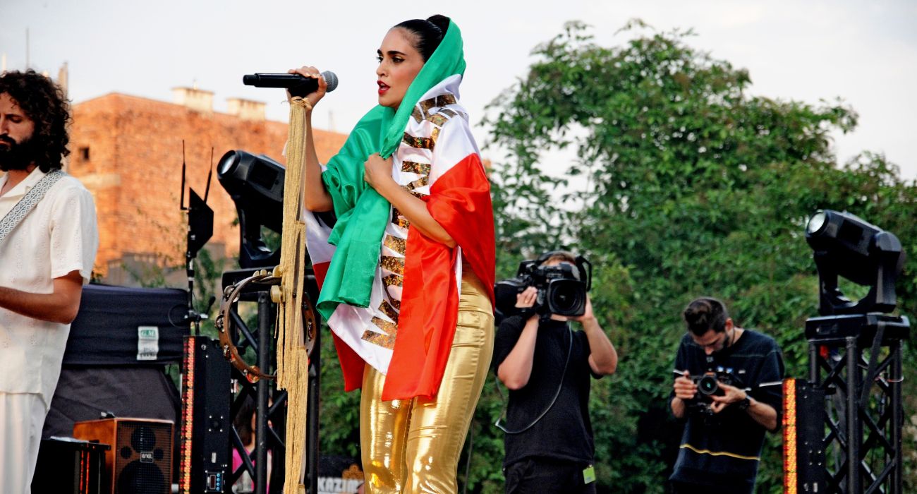 הזמרת לירז צ'רכי עטופה בדגל איראן ועליו המילים: "נשים, חיים, חירות"